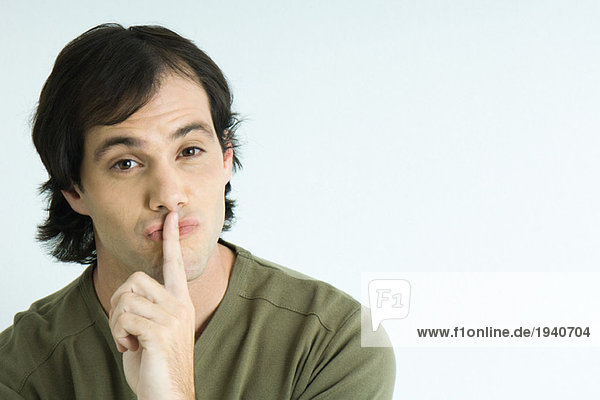 Man with finger over lips  portrait