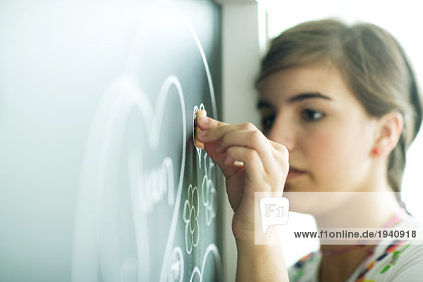 Teen girl drawing on chalkboard