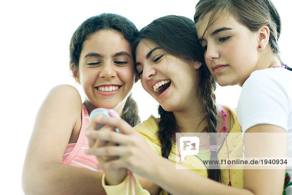 Junge Freundinnen schauen zusammen aufs Handy  lachend