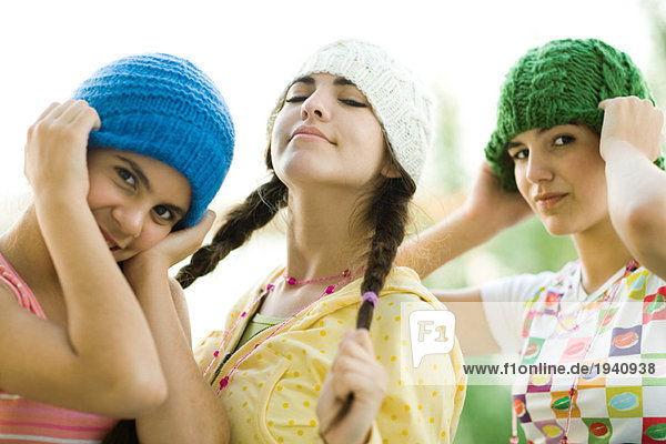 Young female friends wearing knit hats  looking at camera