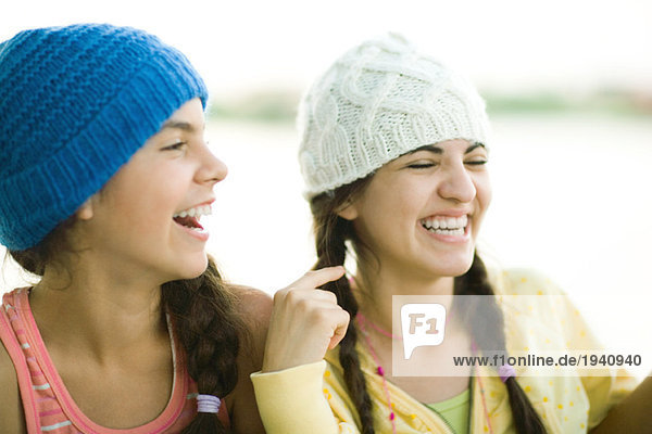 Young female friends wearing knit hats  laughing