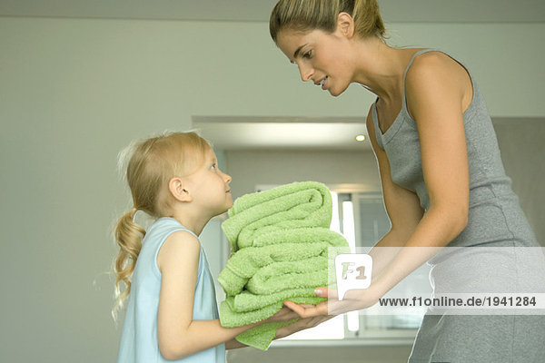 Mädchen  die ihre Mutter mit Handtüchern ausstattet.