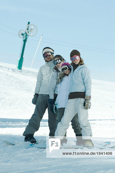 Group of snowboarders posing in snow  full length