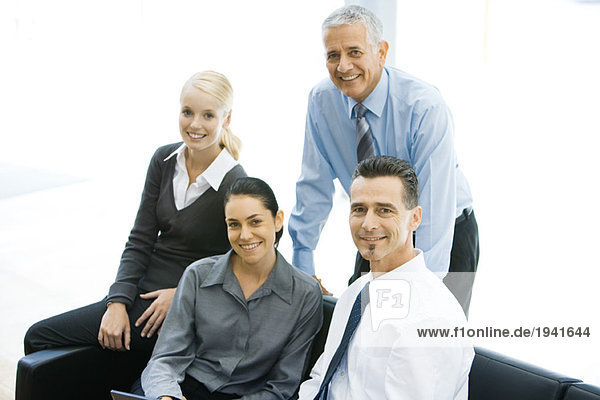 Vier Geschäftspartner lächeln vor der Kamera  Gruppenportrait
