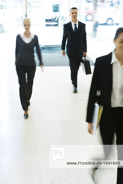 Business professionals walking in lobby  full length  blurred motion