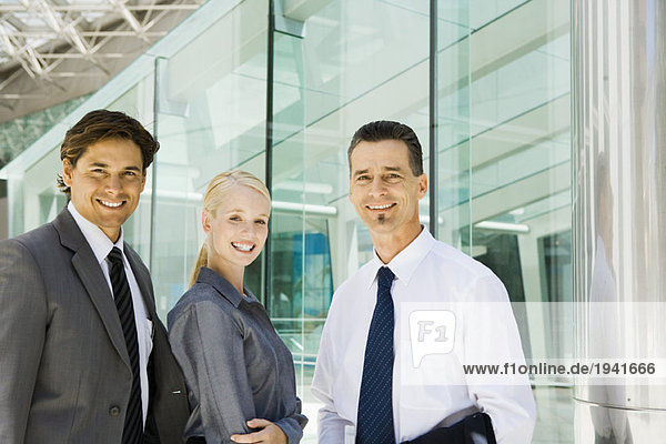Three business associates smiling at camera  waist up  group portrait