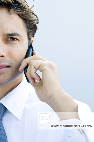 Young businessman using cell phone  cropped view  close-up