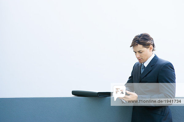 Young businessman using palmtop  looking down