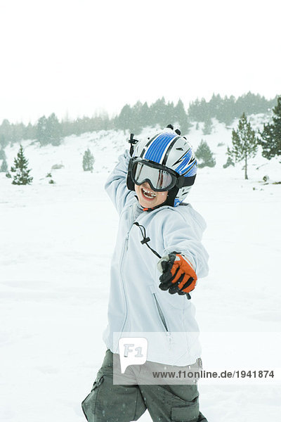 Boy throwing snowball  dressed in ski clothing  three quarter length