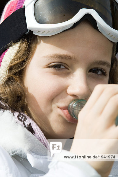 Girl wearing ski gear  drinking from bottle  close-up