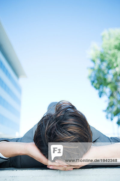 Businessman lying on ground  surface level view