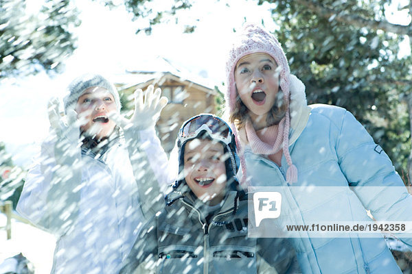 Junge Freunde im fallenden Schnee stehend  lächelnd  tailliert