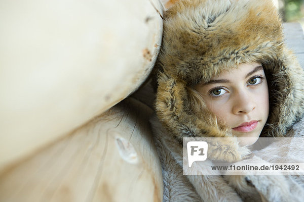 Preteen girl  wearing fur hat  wrapped in fur blanket  close-up