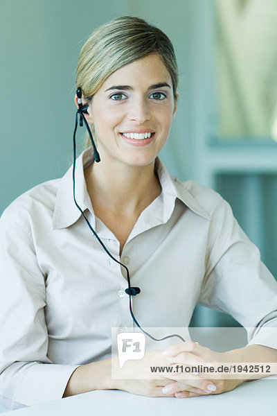 Young businesswoman wearing headset  smiling at camera  waist up