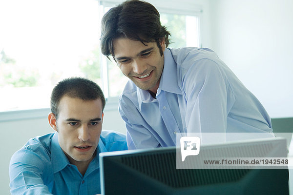 Two businessmen looking at computer  head and shoulders