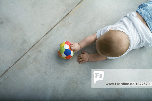 Baby krabbelt auf dem Boden  Halteball  Ansicht von oben