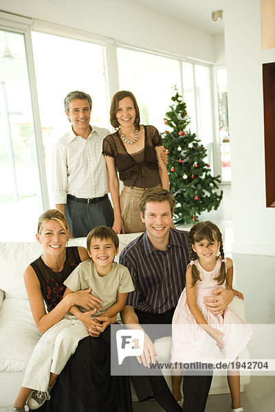 Drei Generationen Familie  Gruppenbild vor dem Weihnachtsbaum