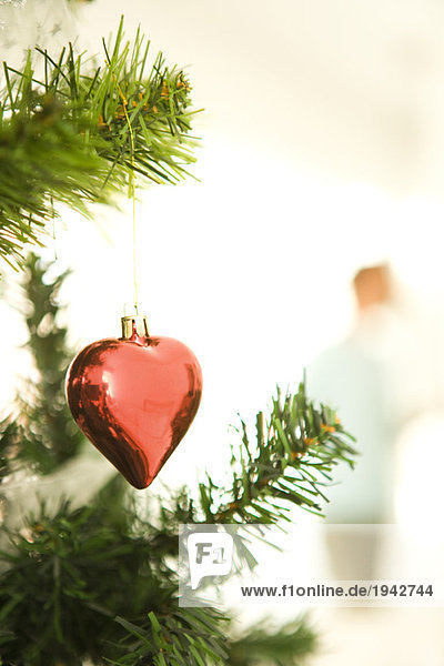 Herzförmiger Weihnachtsschmuck  am Weihnachtsbaum hängend  beschnittene Ansicht