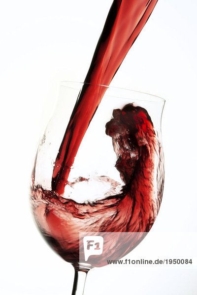 Rotwein  der in das Flügelglas fließt