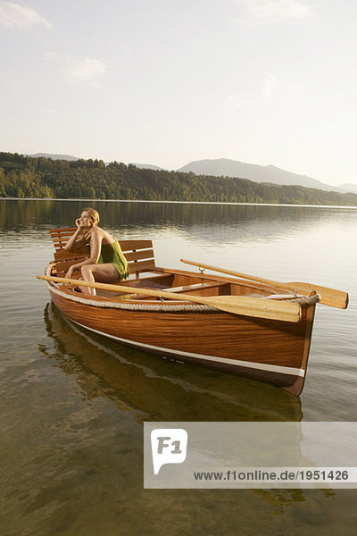 Junge Frau auf einem Ruderboot im See sitzend