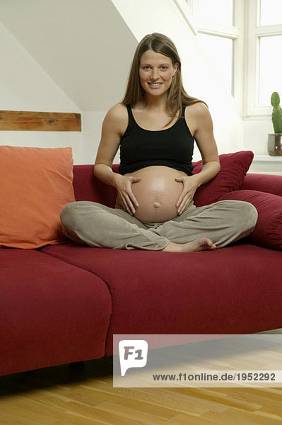 Schwangere Frau mit Händen auf dem Bauch