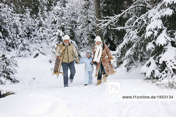 Österreich  Salzburger Land  Junge (6-7) mit Eltern im Schnee unterwegs
