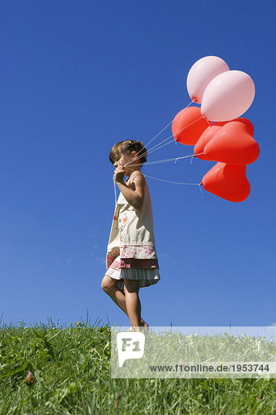 Mädchen (7-9) hält Ballons  Seitenansicht