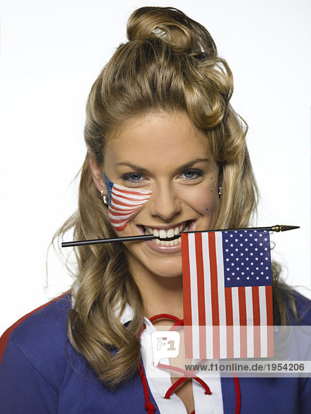 Junge Frau mit US-Flagge zwischen den Zähnen  Portrait
