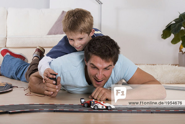 Vater und Sohn (6-7) spielen mit Spielzeugautos