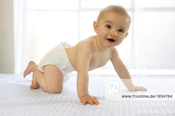 Baby Junge (6-12 Monate) kriechend  lachend  Seitenansicht