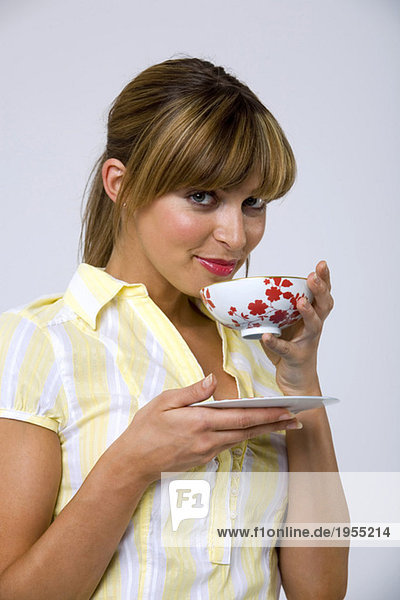 Junge Frau trinkt Tee  Porträt  Nahaufnahme