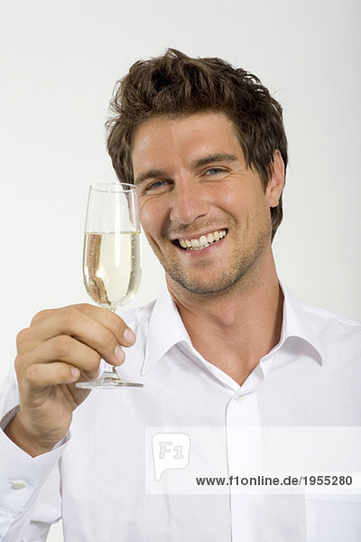 Young man holding glass of champagne  close-up  portrait