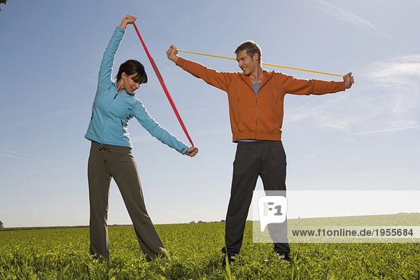 Young couple exercising with resistance band