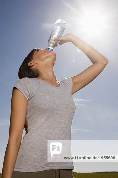 Junge Frau trinkt aus der Wasserflasche