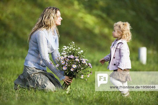 Mutter und Tochter mit Blumenstrauß,  Seitenansicht