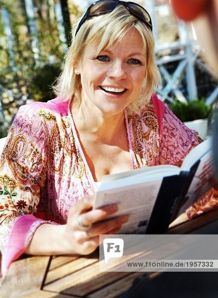 Woman sitting outdoors reading a book