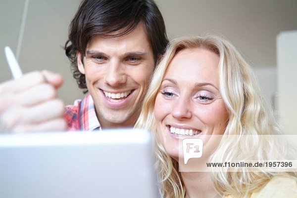 Glückliches junges Paar vor dem Computer