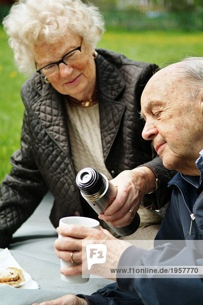 Ältere Menschen beim Kaffee im Freien