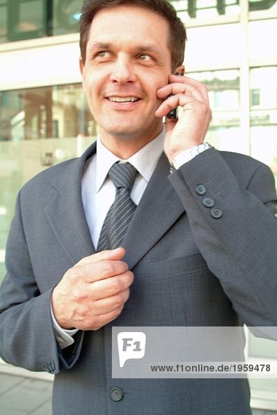 Happy businessman speaking in the phone