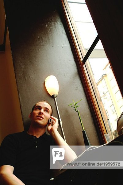 Ein Mann telefoniert in einem Café.