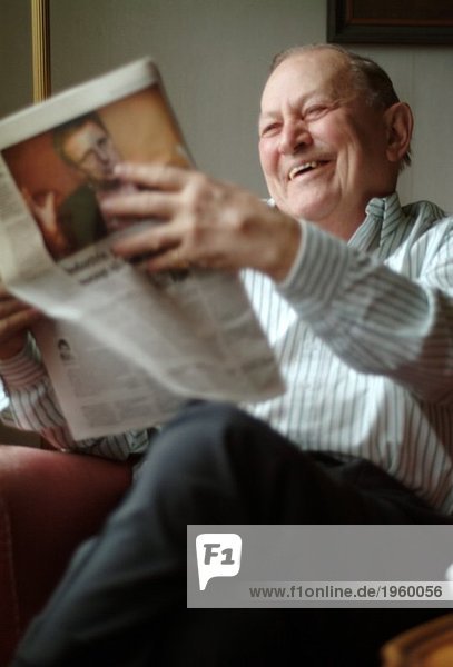 Glücklicher älterer Mann beim Zeitungslesen