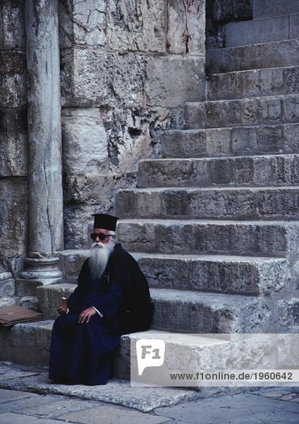 Priester in der Treppe sitzend