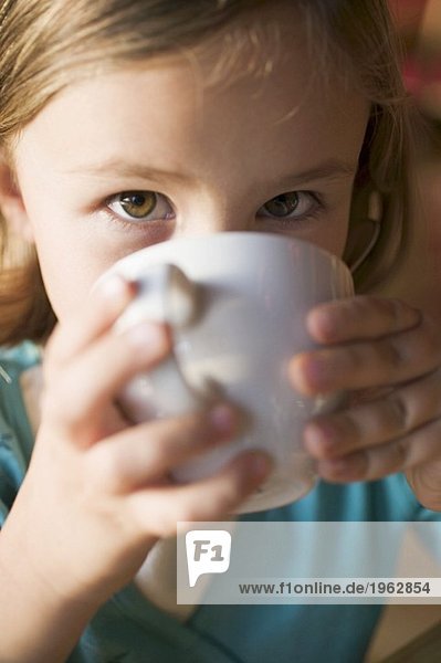 Junges Mädchen trinkt eine Tasse heisse Schokolade