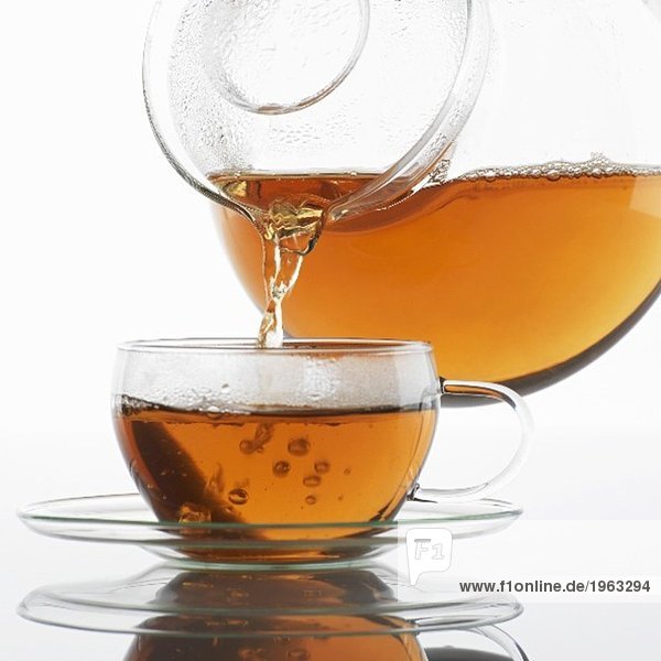 Tee in eine Glastasse eingiessen