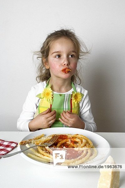 Mädchen isst Makkaroni mit Tomatensauce