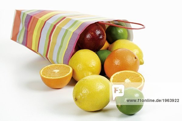 Umgekippte Papiertüte mit Zitrusfrüchten