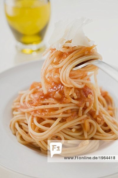 Spaghetti mit Tomatensauce und Parmesan auf Gabel und Teller