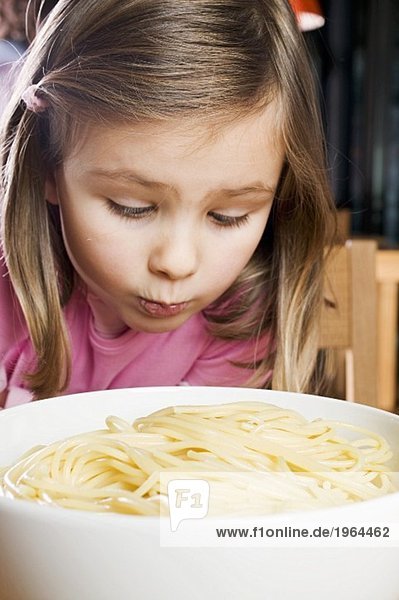 Mädchen betrachtet traurig gekochte Spaghetti