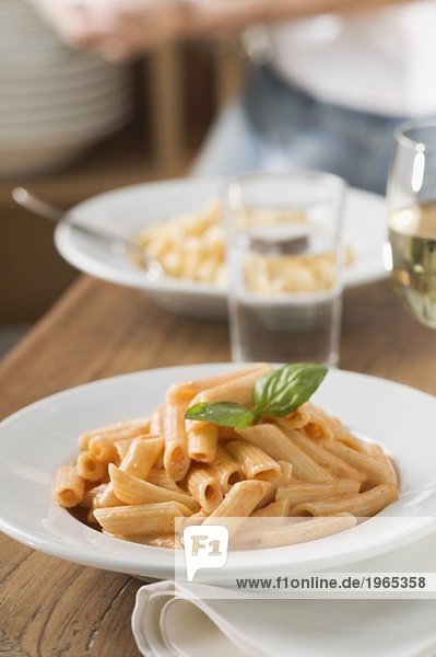 Penne with tomato sauce on laid table