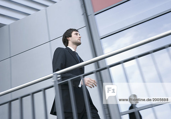 Mann geht am Treppenhaus eines Bürogebäudes entlang